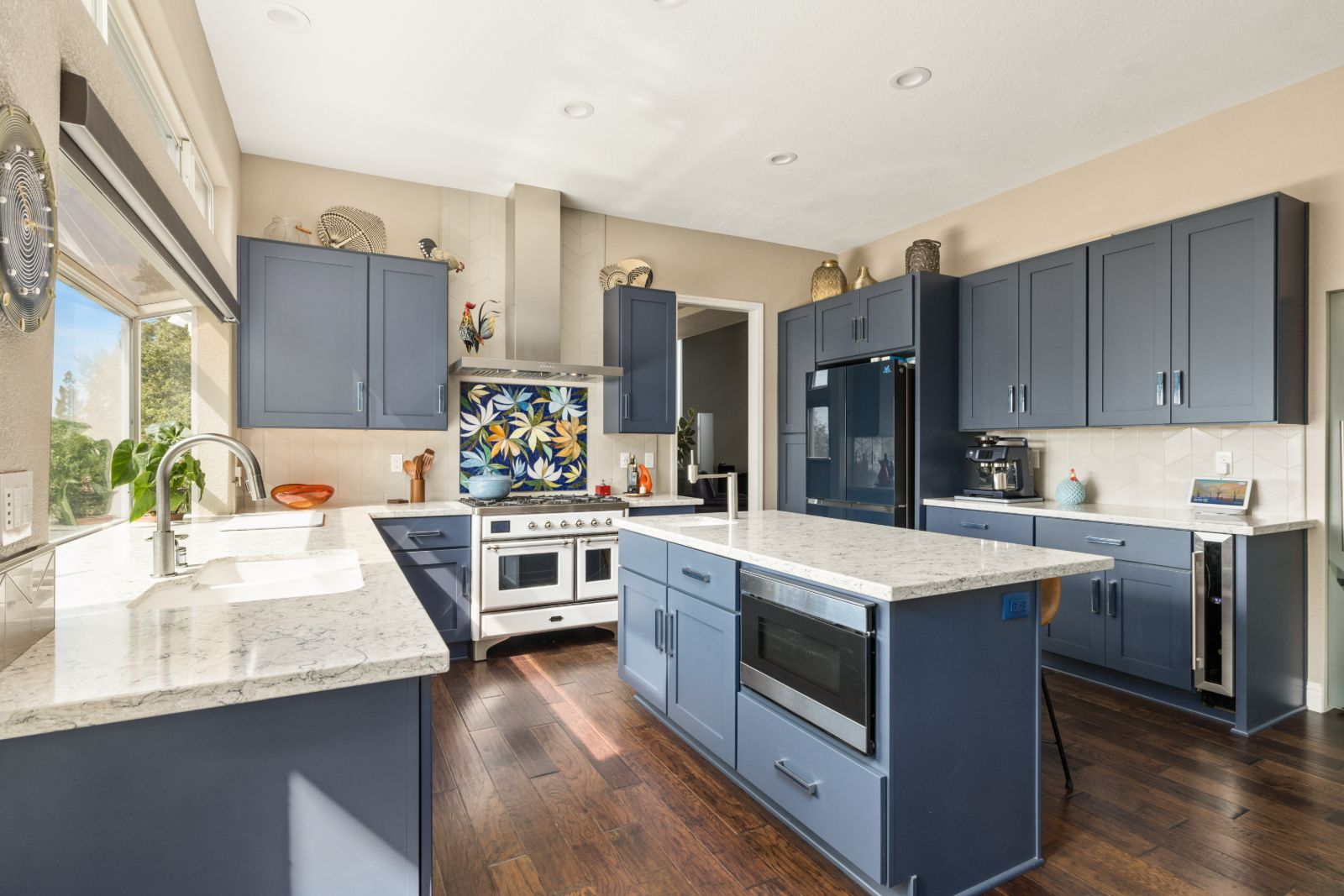 Remodeled kitchen with navy shaker cabinets, quartz counters and a hand-cut mosaic range backsplash