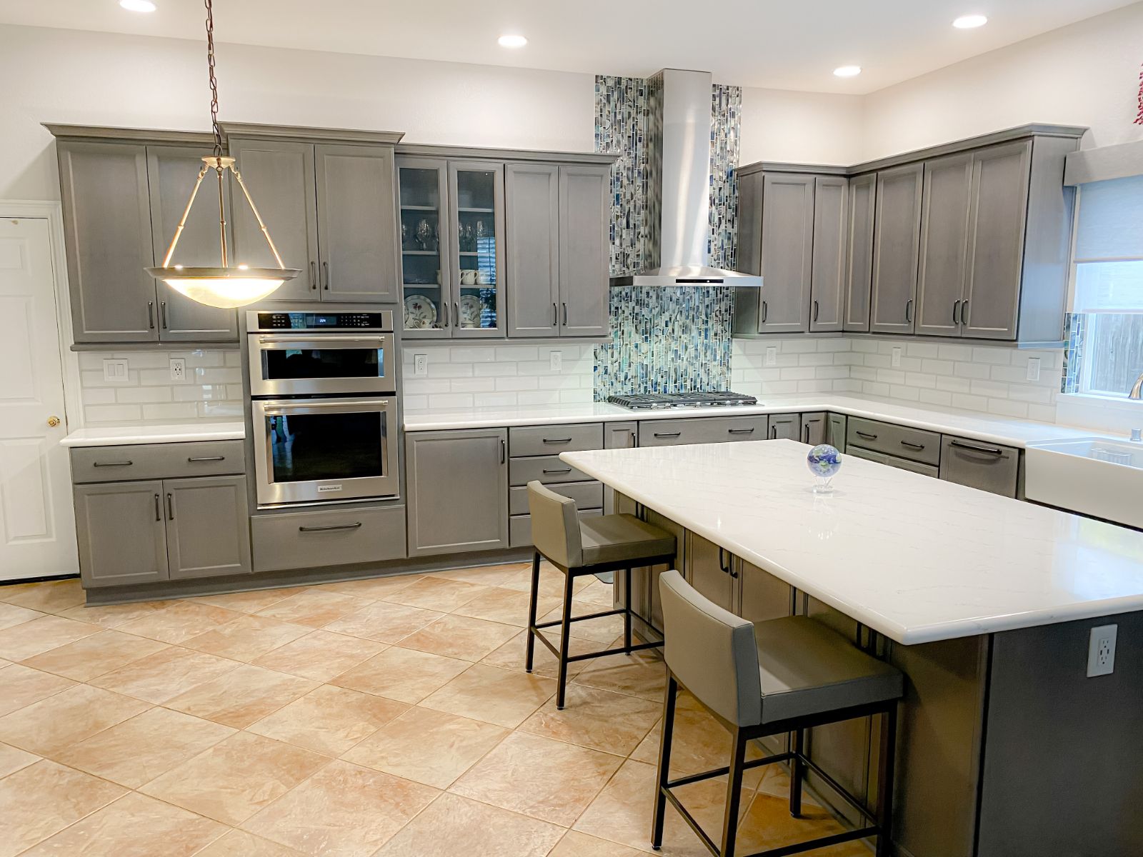 Quartz countertops with glass mosaic and subway tile backsplash
