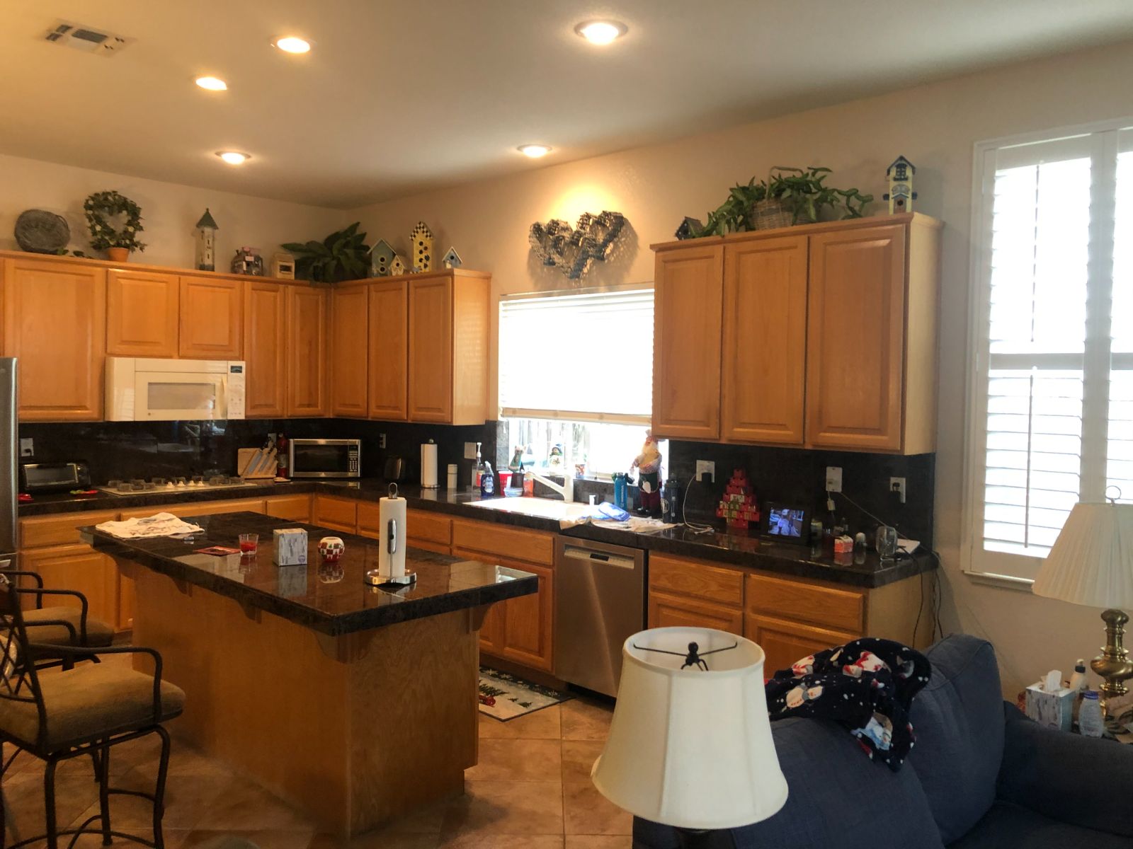 Original oak kitchen with dark granite counters, a peninsula island and a white over-range microwave